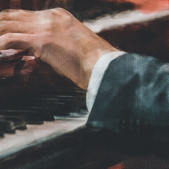 The hand on the keys of the piano.